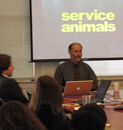 Gary Karp at a conference table in front of a video screen conducting a workshop